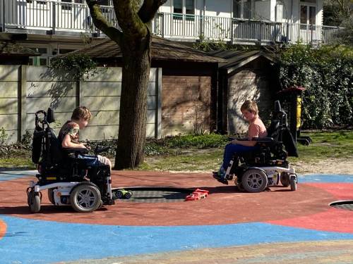 2 kinderen in rolstoel in speeltuin