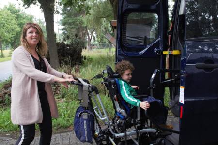 Sami in de bus met begeleider 